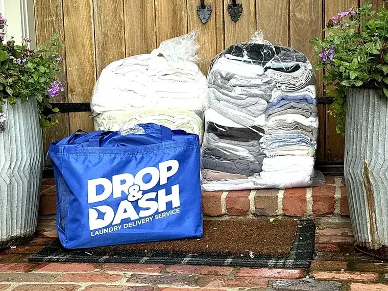 Wrapped stacks of clean, folded laundry and a Drop & Dash bag delivered back to the front door