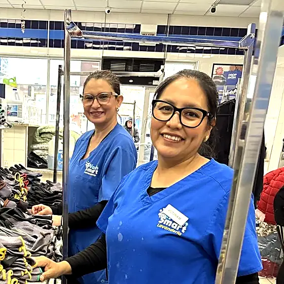 Two team members sorting a commercial laundry order