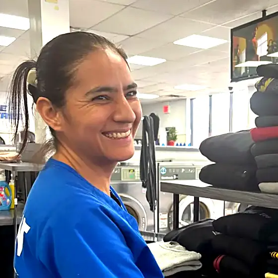 A team member folding clothes at our facility