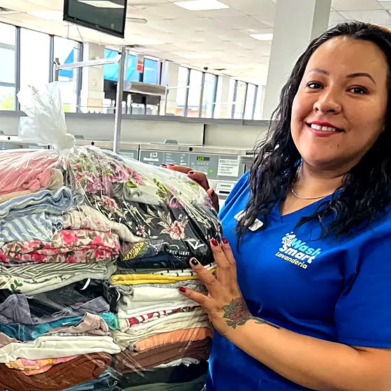 A smiling team member next to a wrapped order